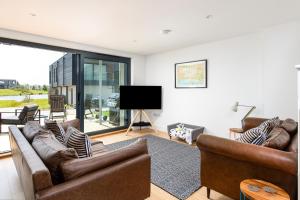 ein Wohnzimmer mit Sofas und einem Flachbildfernseher in der Unterkunft Brightside SV35 Silverlake Dorset in Warmwell