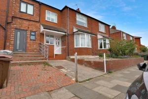 a brick house with a driveway in front of it at Pass the Keys Seaside Sanctuary Cullercoats – Walk to the Beach in Cullercoats