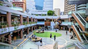 eine Gruppe von Menschen, die in einem Innenhof in einer Stadt spazieren gehen in der Unterkunft O's Apartment Hotel In Kyobashi 3FA in Osaka