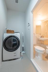 eine Waschmaschine in einem Badezimmer mit Toilette in der Unterkunft O's Apartment Hotel In Kyobashi 3FA in Osaka