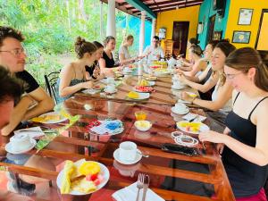 a group of people sitting around a table eating food at Palitha Homestay in Sigiriya +85 photos