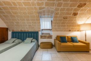 a bedroom with two beds and a couch at Palazzo Arco Cadura Hotel & Spa in Galatina +86 photos