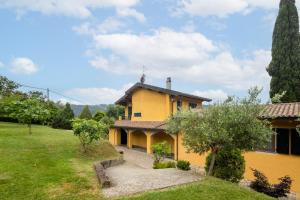 an exterior view of a yellow house with a yard at Villa Nicola in Camaiore