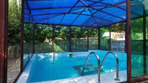an indoor swimming pool with a blue roof and glass walls at Вила Лонгоз in Dŭbravino