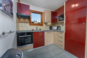 a kitchen with red cabinets and a red refrigerator at Chalet Apartment Monêtier in Le Monêtier-les-Bains +33 photos