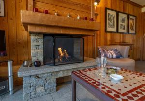 a living room with a fireplace and a table at Chalet Apartment Monêtier in Le Monêtier-les-Bains