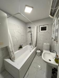 a white bathroom with a tub and a sink at Quiet House in İznik