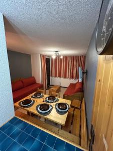ein Wohnzimmer mit einem Tisch in der Mitte eines Zimmers in der Unterkunft Appartement cosy quartier Napoléon in Val Cenis