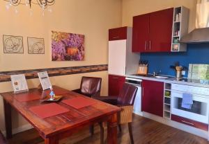 een keuken met een houten tafel en een keuken met rode kasten bij Ferienwohnung an der Nicolaikirche in Lüneburg +4 foto's