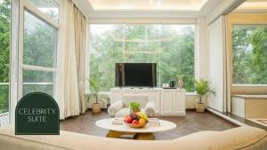 ein Wohnzimmer mit einem großen Fenster und einem Fernseher in der Unterkunft Narayana Sanctuary Resort by Salvus, Tapovan in Rishikesh