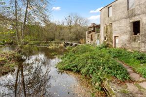 an old building sitting next to a river at La Rousseline - Bord de Sèvre, Calme & Moderne in Boussay
