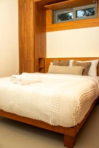 um quarto com uma cama grande com cabeceira de madeira em House B thonningii - warm minimalism em Nanyuki mais 11 fotografias