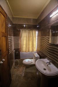 a bathroom with a sink and a toilet and a window at JCT Exclusive 3 Bedroom Private Houseboat with All Meals in Alleppey