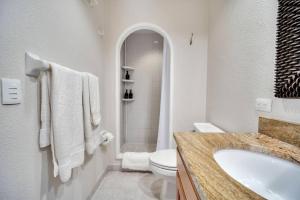 ein weißes Badezimmer mit Waschbecken und Toilette in der Unterkunft Los Cabos - Costa Azul Apartments in San José del Cabo + 4 Fotos
