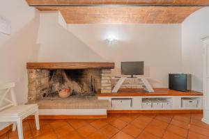 Una sala de estar con televisión y chimenea. en Agriturismo Il Piaggione, en Venturina Terme