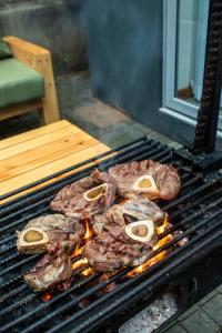 um monte de carne a cozinhar numa grelha em House B thonningii - warm minimalism em Nanyuki