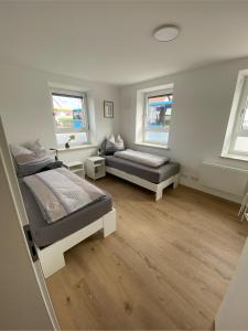 a bedroom with two beds and two windows at kreuzwirt bayern in Essenbach