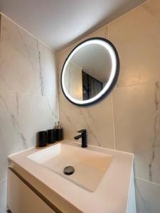 La Celle-sous-GouzonLe Bohème的墙上有水槽和镜子的浴室