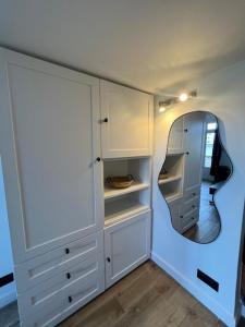 La Celle-sous-GouzonLe Bohème的房间里有白色橱柜和一面圆形镜子