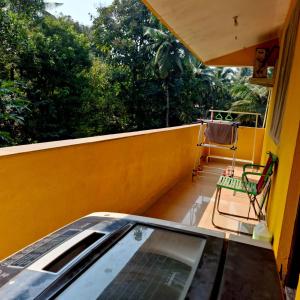 a balcony with a glass table and a chair at Palolem by Casa de Palmora in Canacona