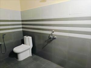 a bathroom with a white toilet and a shower at Daya Dharmam Residency in Tiruvannāmalai