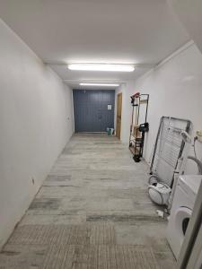 een lege gang van een kantoorgebouw met een kamer met een deur bij Maison de Vacances 2 Chambres avec rooftop in Thuir