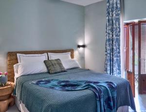 a bedroom with a bed with a blue blanket on it at Gare du Nord in Sant Joan de Labritja
