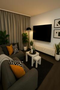 a living room with a couch and a flat screen tv at La Suite Secreta del Júcar in Alcalá del Júcar +11 photos