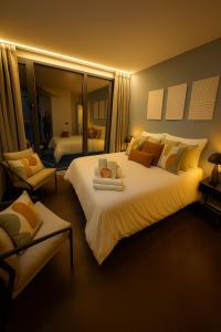 a bedroom with a large white bed and a chair at La Suite Secreta del Júcar in Alcalá del Júcar