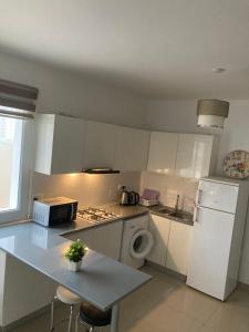 a kitchen with a white refrigerator and a washing machine at Квартира Апартаменты in Paralimni