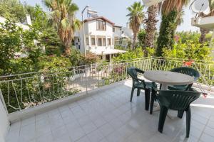 a balcony with a table and chairs and a fence at Flower Villa Apart in Kemer