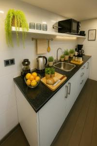 a kitchen counter with a bowl of oranges and a sink at La Suite Secreta del Júcar in Alcalá del Júcar