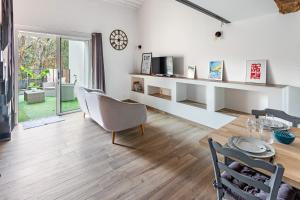 a living room with a table and chairs and a clock at La Rousseline - Bord de Sèvre, Calme & Moderne in Boussay