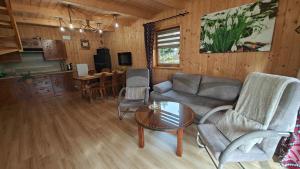 a living room with a couch and a table at Domki u Jacka z sauną widok na Kasprowy in Ząb