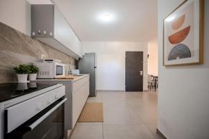 a kitchen with a stove and a microwave at Ashdod 5 rooms with mamad in Ashdod
