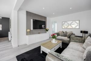 a living room with a couch and a tv at Seaside Bungalow with Garden & Inflatable Hot Tub in Hamworthy