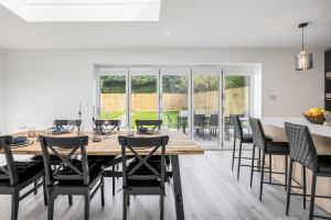 a dining room with a wooden table and chairs at Seaside Bungalow with Garden & Inflatable Hot Tub in Hamworthy