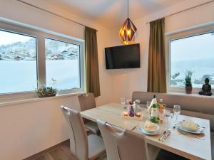 a dining room with a table and two windows at Apartment in Piesendorf near Ski Slopes in Piesendorf