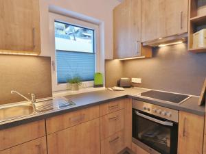 a kitchen with wooden cabinets and a sink and a window at Apartment in Piesendorf near Ski Slopes in Piesendorf