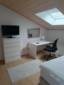 une chambre avec un lit, un bureau et une télévision dans l'établissement Devona Apart, à Langenselbold