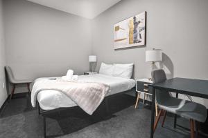 Una habitación de hotel con una cama, un escritorio y una mesa. en CozySuites Modern 1BR Downtown Pitts 10, en Pittsburgh