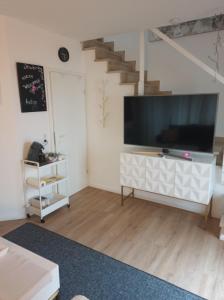 un salon avec une grande télévision et un escalier dans l'établissement Devona Apart, à Langenselbold