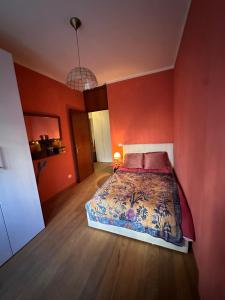 a bedroom with a bed in a red wall at WhiteHome in Conegliano