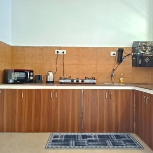a kitchen with a stove and a microwave on a counter at Palolem by Casa de Palmora in Canacona
