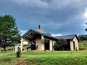 哈内茨堡Silver Mist Resort, Haenertsburg的一座黑色屋顶的白色小房子
