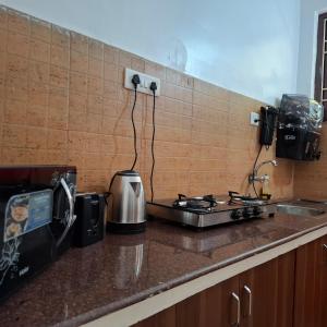 a kitchen counter with a stove and a toaster at Palolem by Casa de Palmora in Canacona