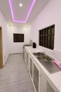 uma cozinha com um lavatório e um tecto roxo em Your stylish temporary home in Lomé em Lomé mais 3 fotografias