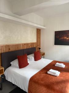 a bedroom with a large bed with two red pillows at Globo Happy Hostel in Angra do Heroísmo