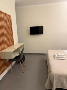 a room with a desk and a table and a tv at Globo Happy Hostel in Angra do Heroísmo