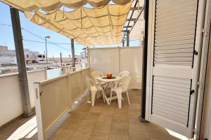 einen Balkon mit einem Tisch und Stühlen darauf in der Unterkunft Stelle Gemelle Residence by ThePuglia in Torre Lapillo